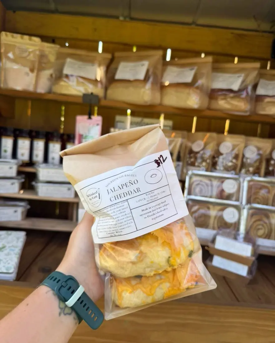 A kraft bag of jalapeño cheddar sourdough bagels held up at the stand