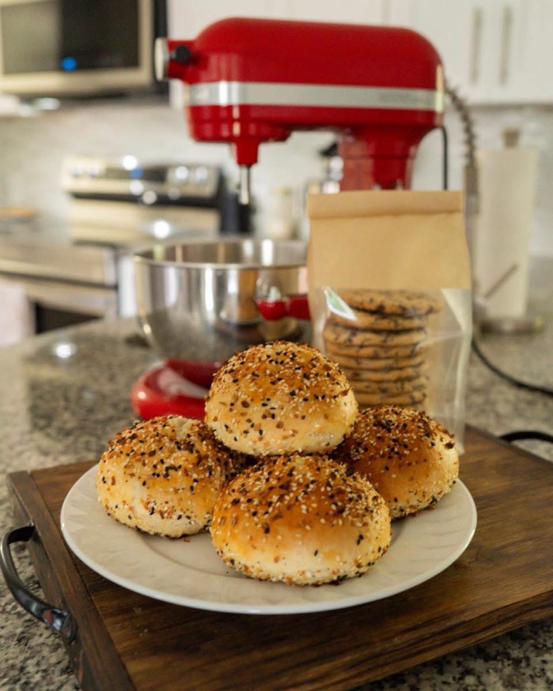 A plate of Everything bagels on a wooden board in a home kitchen