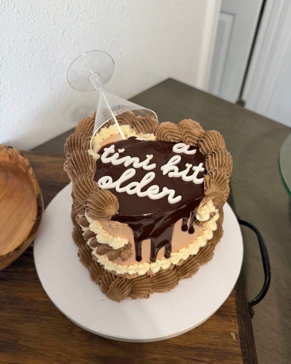 A chocolate buttercream cake with a ganache drip and piped lettering
