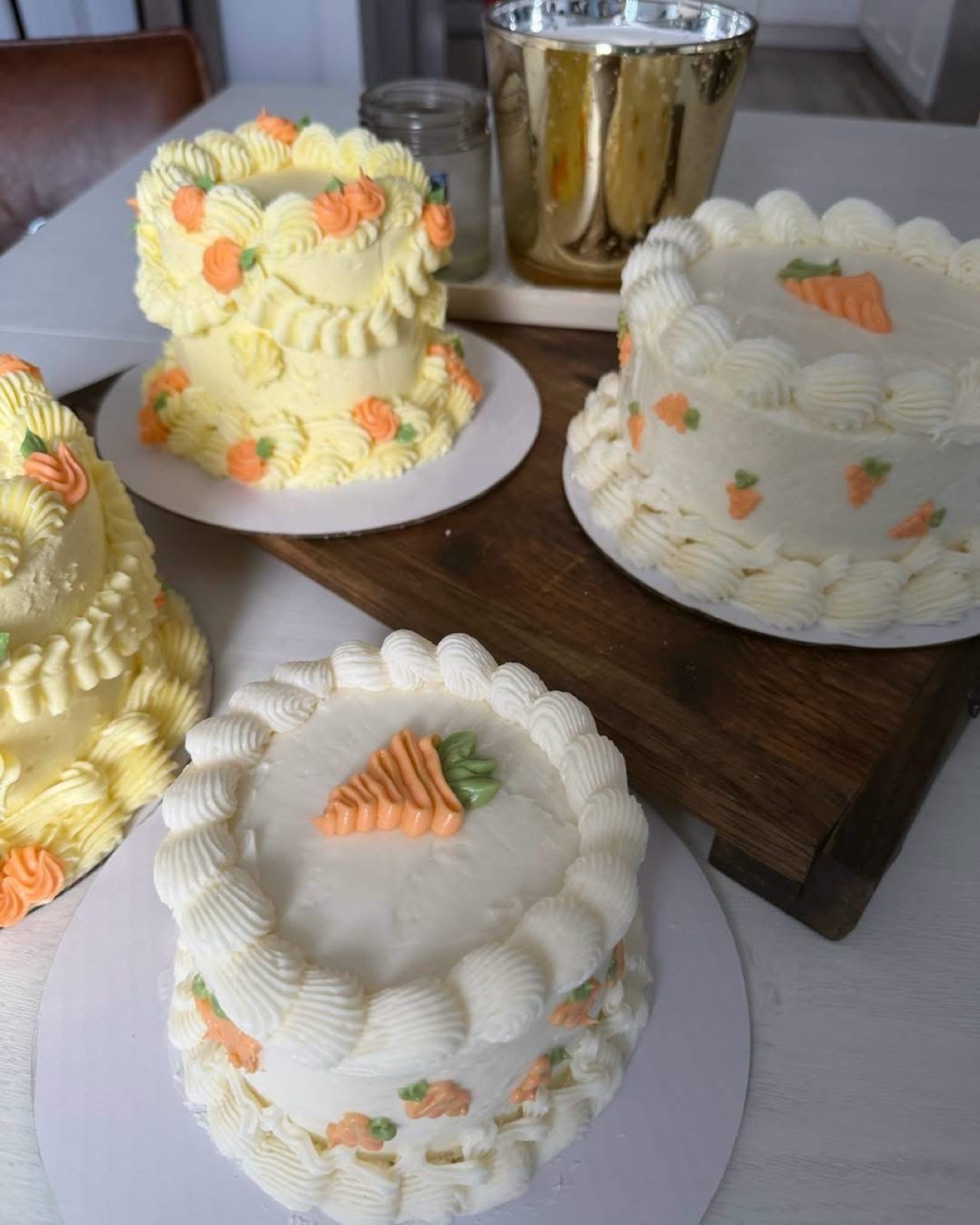Four carrot cakes finished in buttercream shells with piped carrots